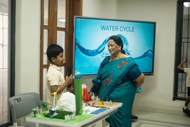 Children explaining a water-cycle project during Project Day